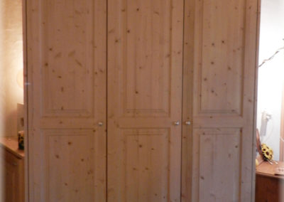 Armoire en sapin verni, porte assemblée.