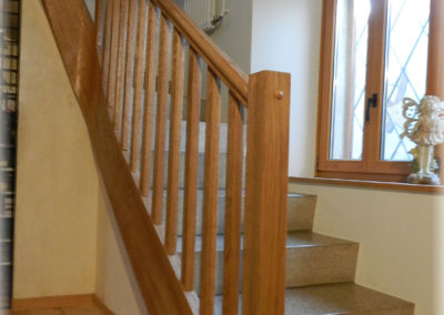 Limon et main courante en chêne brossé verni adapté à l'escalier.