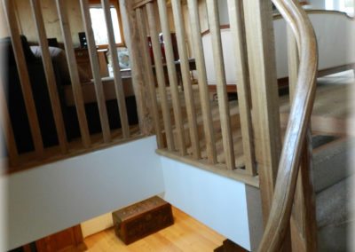 Limon et main courante en chêne brossé verni adapté à l'escalier.