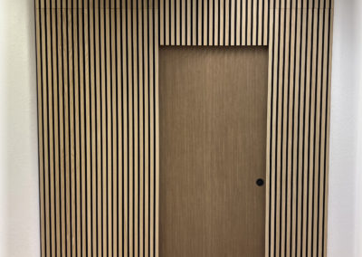 Paroi de séparation pour cabinet de physio avec porte coulissante à galandage (rentre dans la paroi). Paroi phonique. Porte recouverte d'un adhésif architectural.