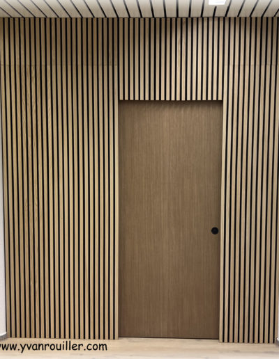 Paroi de séparation pour cabinet de physio avec porte coulissante à galandage (rentre dans la paroi). Paroi phonique. Porte recouverte d'un adhésif architectural.