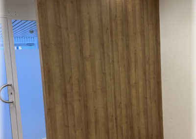 Paroi de séparation d'entrée d'un cabinet de physio en mélaminé.