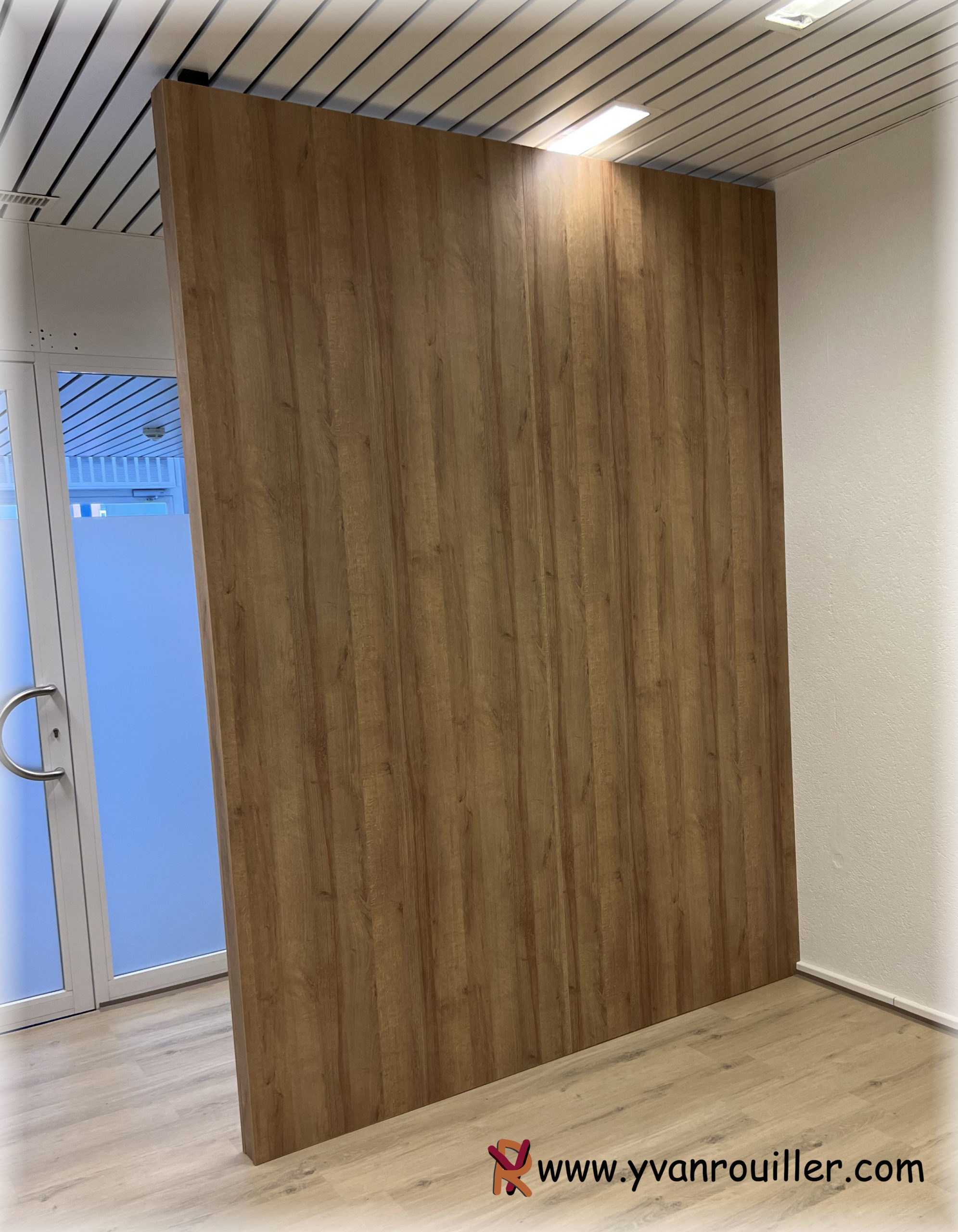 Paroi de séparation d'entrée d'un cabinet de physio en mélaminé.